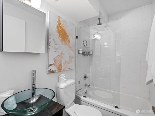 bathroom featuring tiled shower / bath combo and toilet