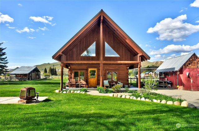 back of property featuring a storage unit and a lawn