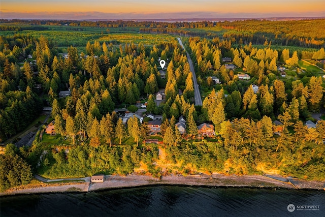 aerial view at dusk featuring a water view