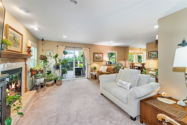 living room featuring a premium fireplace, a wealth of natural light, carpet floors, and recessed lighting