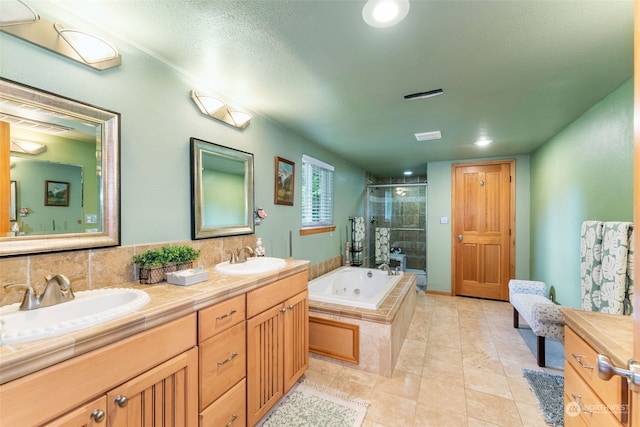 full bath featuring a stall shower, a jetted tub, double vanity, and a sink