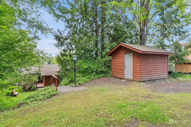 view of yard featuring an outbuilding, a storage shed, and a deck