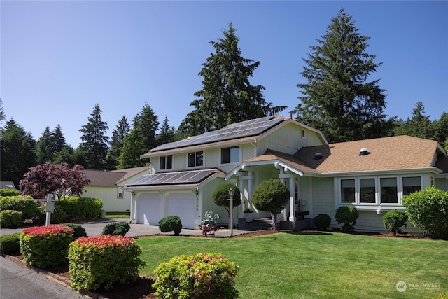 view of front of property featuring solar panels, a garage, and a front yard