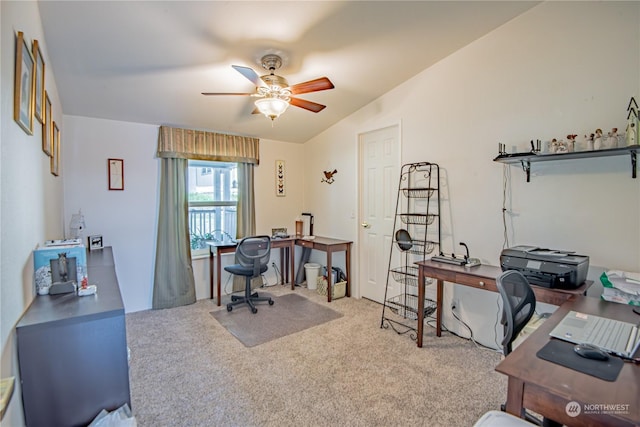 carpeted office space featuring vaulted ceiling and ceiling fan