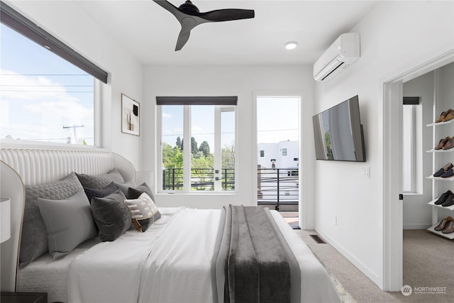 carpeted bedroom with ceiling fan and a wall mounted AC