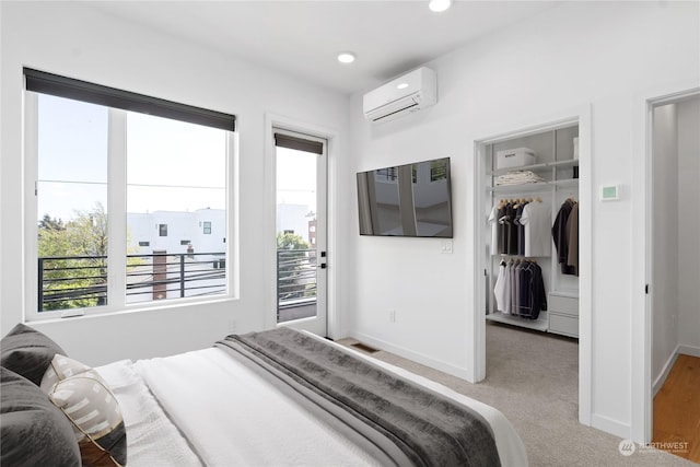 carpeted bedroom with a wall mounted AC and a closet