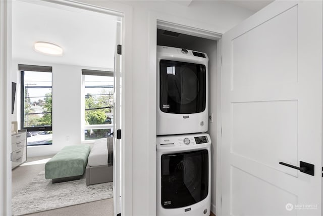 laundry room with stacked washer / dryer and light carpet