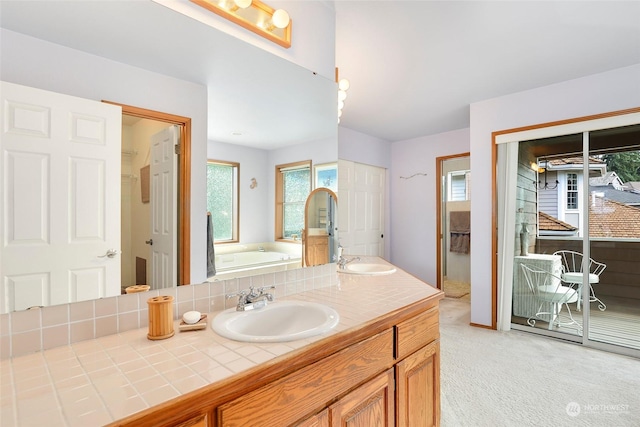 bathroom with a bath, double vanity, and a sink