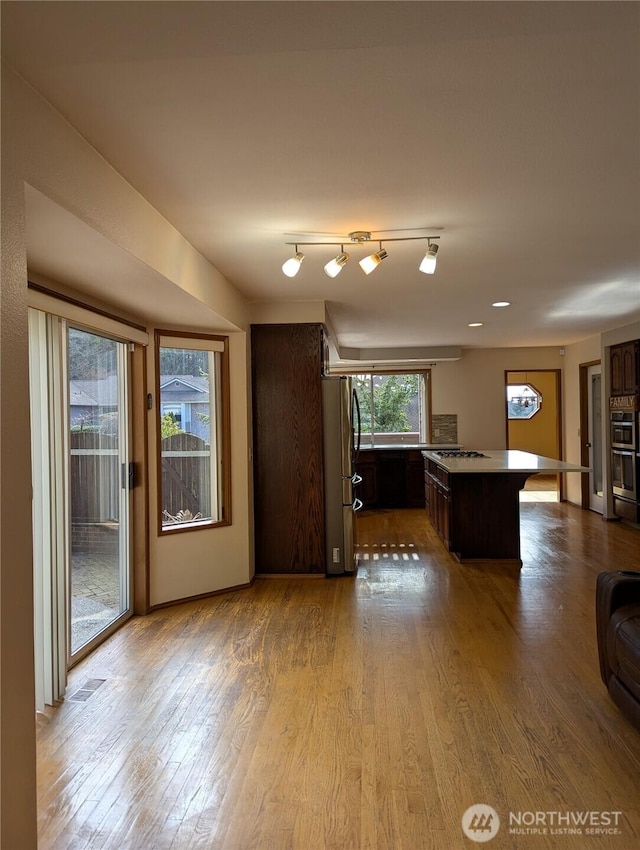 unfurnished living room with visible vents and wood finished floors