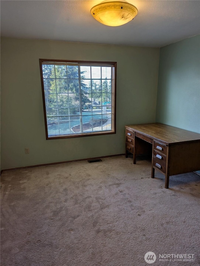 unfurnished office with visible vents, carpet flooring, and a textured ceiling