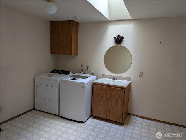 washroom featuring baseboards, a sink, light floors, and separate washer and dryer