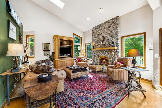 132 Hellem Dr, Packwood, WA 98361 - living area with high vaulted ceiling, a skylight, light wood-style floors, a stone fireplace, and recessed lighting