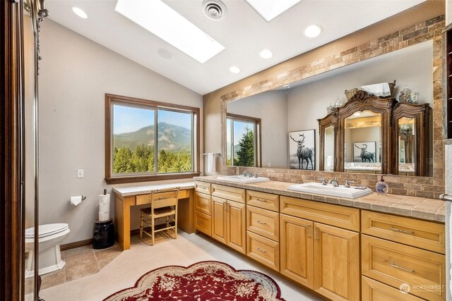 132 Hellem Dr, Packwood, WA 98361 - bathroom featuring a skylight, double vanity, recessed lighting, vaulted ceiling, and tile patterned flooring