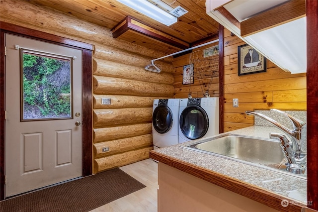 washroom featuring sink, wood ceiling, rustic walls, washing machine and dryer, and light wood-type flooring