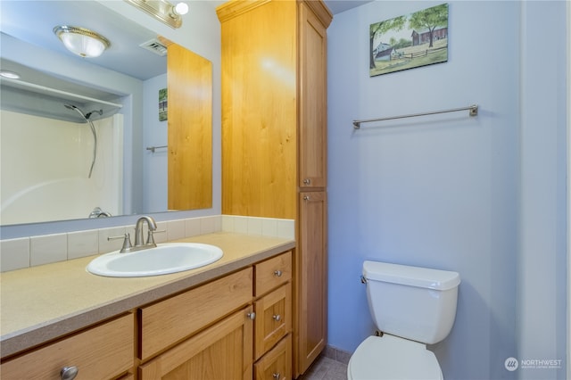 bathroom with vanity, walk in shower, and toilet