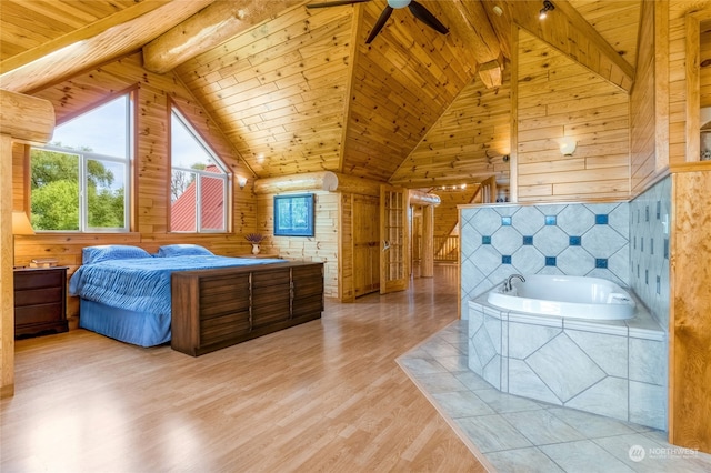 bedroom featuring light hardwood / wood-style flooring, vaulted ceiling with beams, and wooden walls