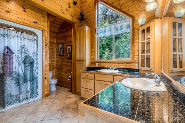 bathroom featuring tile patterned floors, lofted ceiling, toilet, wood walls, and wood ceiling