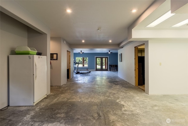 corridor with a skylight, concrete floors, and french doors