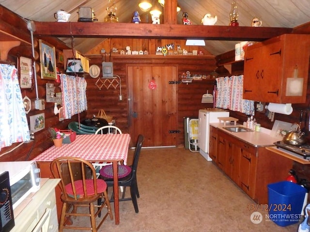 kitchen with light carpet, washer / dryer, lofted ceiling with beams, and sink