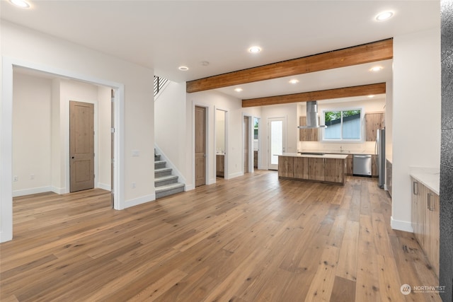 unfurnished living room with light hardwood / wood-style floors and beam ceiling