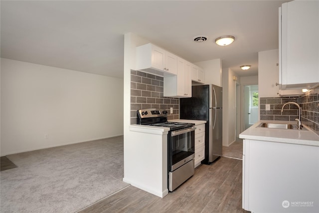 kitchen featuring white cabinetry, sink, electric stove, decorative backsplash, and light wood-type flooring