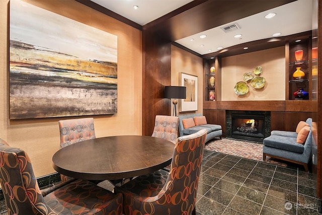 dining space with crown molding and a fireplace