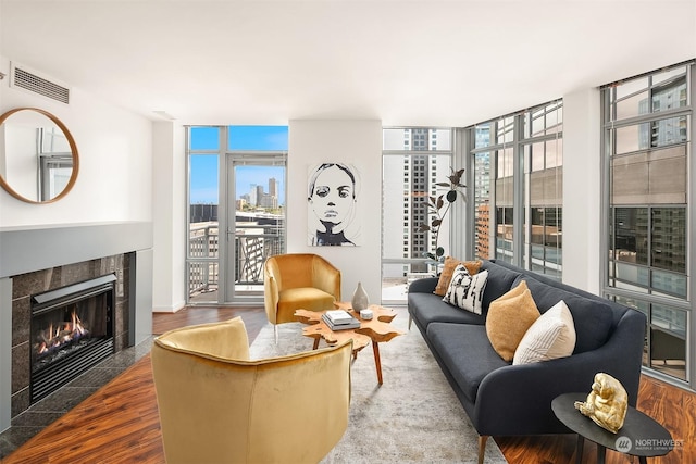 living room featuring a wealth of natural light, wood-type flooring, and a wall of windows