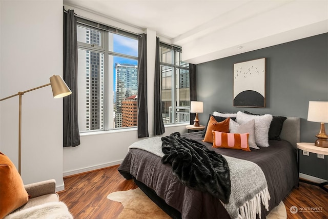 bedroom featuring multiple windows and dark wood-type flooring