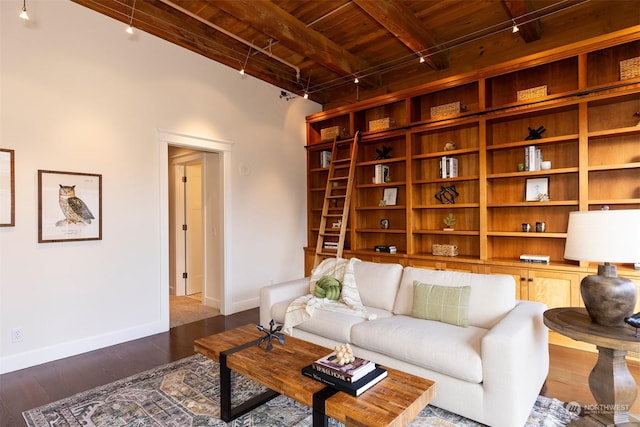 living room featuring beamed ceiling, dark hardwood / wood-style flooring, rail lighting, and wood ceiling