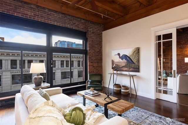 living room with brick wall, beam ceiling, dark hardwood / wood-style flooring, and wood ceiling