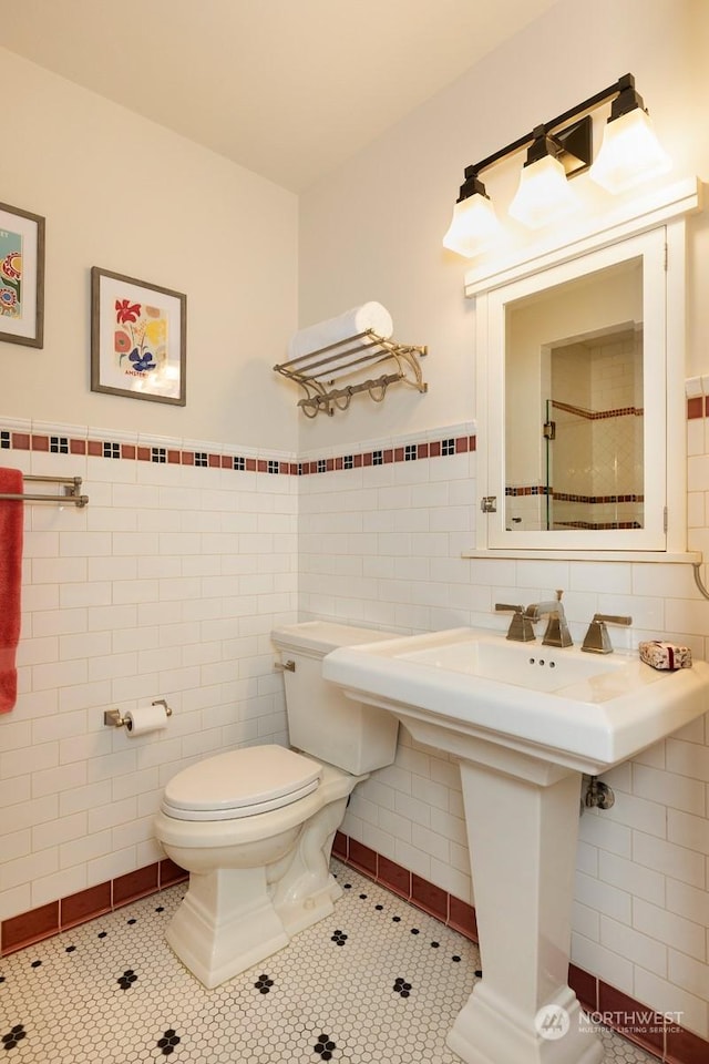 bathroom featuring tile patterned flooring, tile walls, and toilet