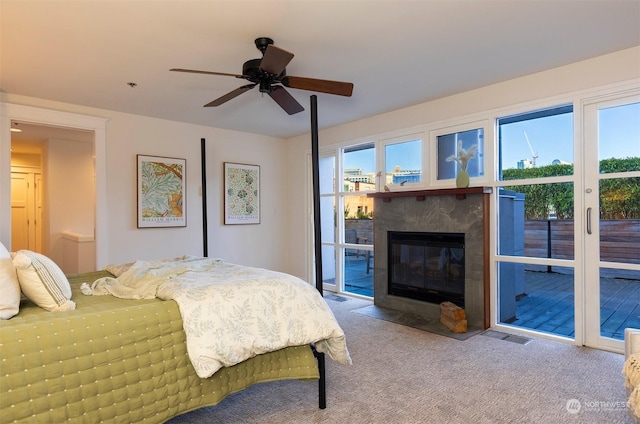 bedroom with carpet floors, access to outside, multiple windows, and ceiling fan