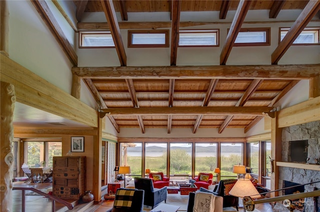 interior space with lofted ceiling with beams, wood ceiling, and a fireplace