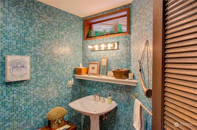 bathroom with sink and tile walls