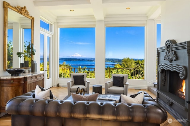 living room featuring a water and mountain view, beamed ceiling, and coffered ceiling