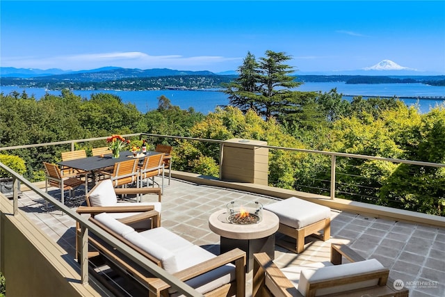 balcony featuring a water and mountain view and a fire pit