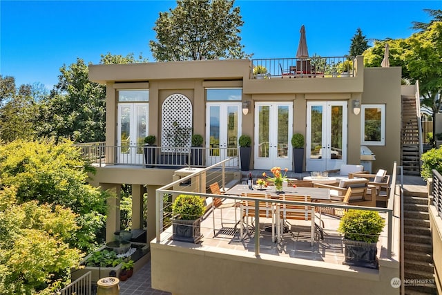 back of property featuring french doors, a balcony, and a patio