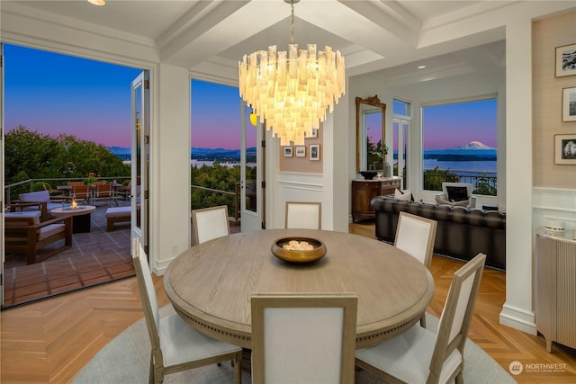 dining space featuring radiator, coffered ceiling, beamed ceiling, a chandelier, and light parquet flooring