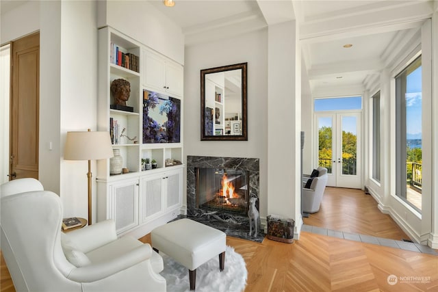 living area featuring a high end fireplace, french doors, and light parquet floors