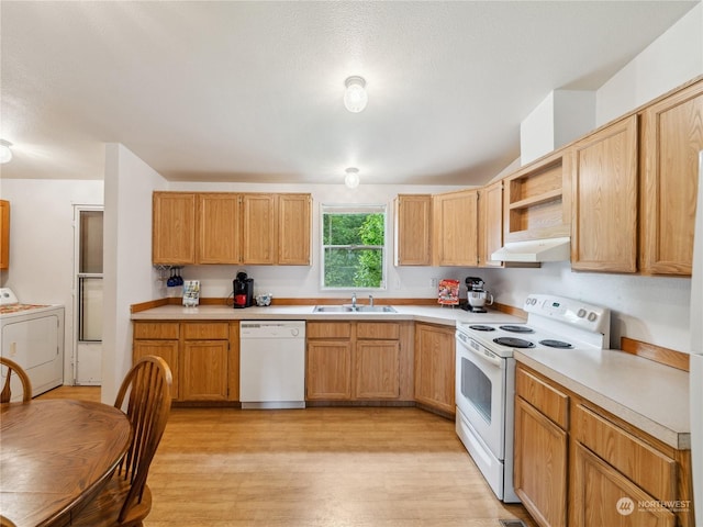 kitchen featuring washing machine and dryer, sink, light hardwood / wood-style floors, and white appliances