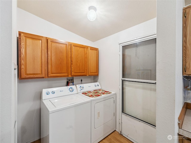 laundry area featuring cabinets, separate washer and dryer, and light hardwood / wood-style flooring