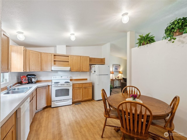 kitchen featuring vaulted ceiling, light hardwood / wood-style floors, sink, white appliances, and a textured ceiling