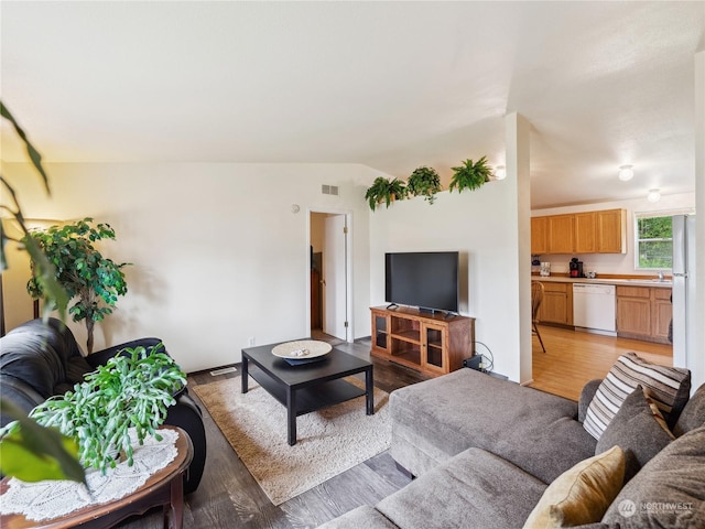 living room featuring lofted ceiling and light hardwood / wood-style flooring