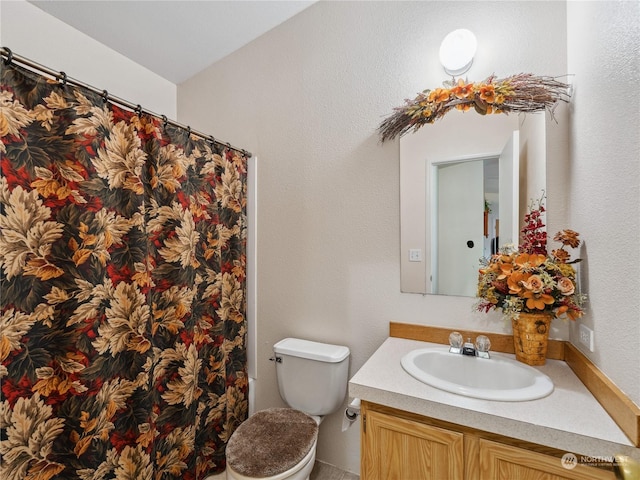 bathroom with toilet, vanity, and curtained shower