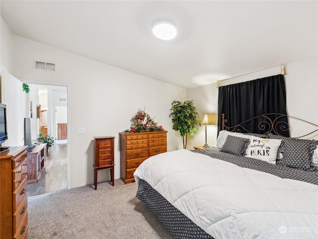 bedroom with lofted ceiling and light colored carpet