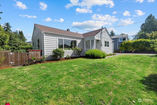 rear view of house featuring a lawn