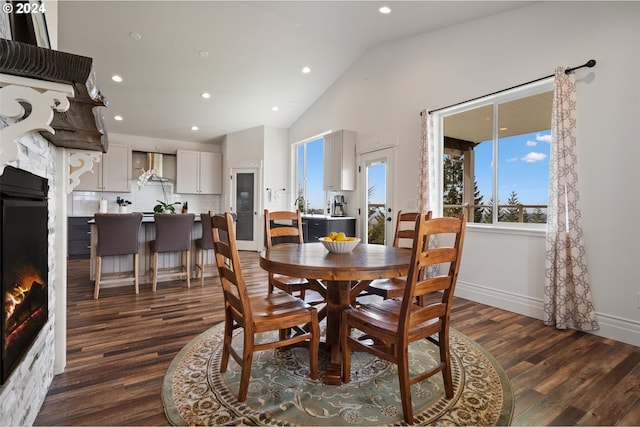 dining space featuring vaulted ceiling and dark hardwood / wood-style floors