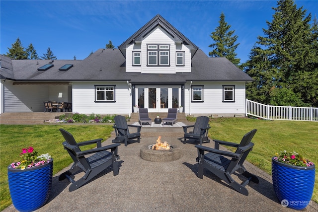 back of property with a patio, french doors, a lawn, and a fire pit