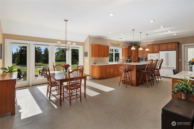 dining area with light tile patterned flooring, sink, french doors, and a notable chandelier