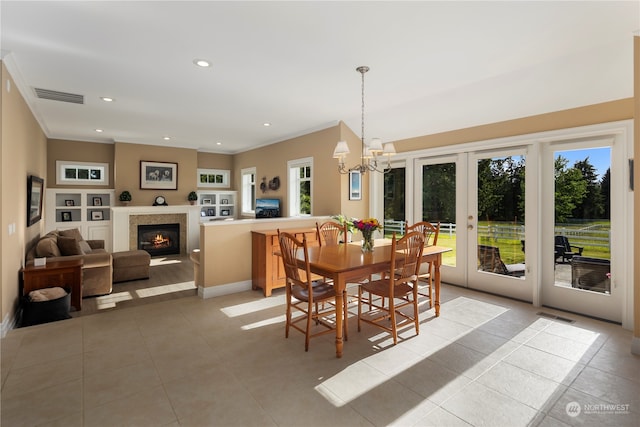 dining area with an inviting chandelier, light tile patterned floors, and plenty of natural light